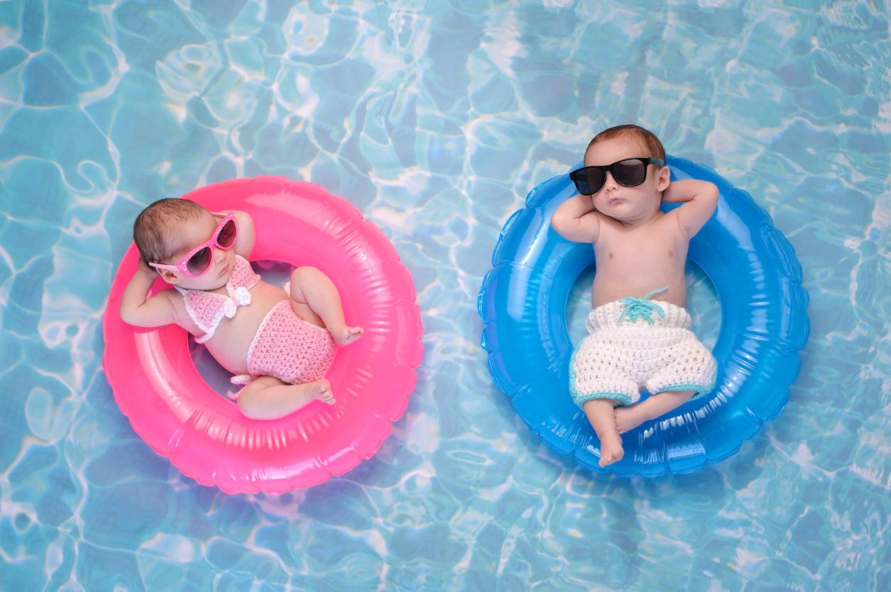 Babies lying in colourful rubber rings with sunglasses on
